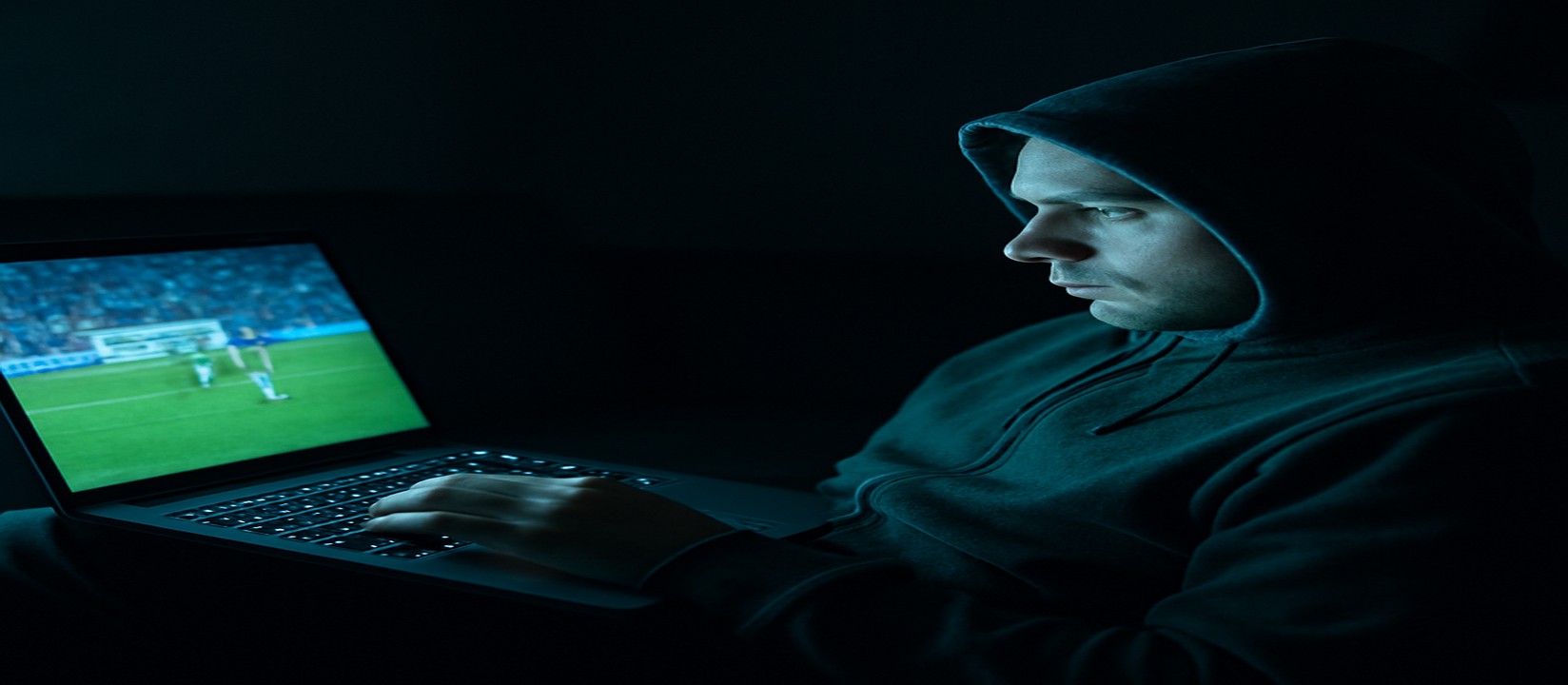 সোফায় বসে ek33 প্ল্যাটফর্মে ল্যাপটপে গেম খেলার একজন ব্যবহারকারী